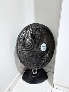 a black fan is sitting in a room at Apartamento Confortável Próx Unesp in Botucatu +47 photos