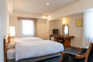 a hotel room with a bed and a desk at Mori-no-Hotel Sendai in Sendai