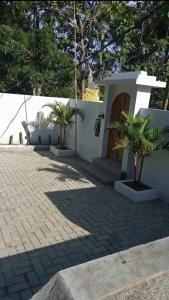 a small white building with two palm trees in front of it at Umah Pororo in Karangasem