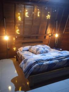 a bedroom with a bed with lights on the wall at Umah Pororo in Karangasem