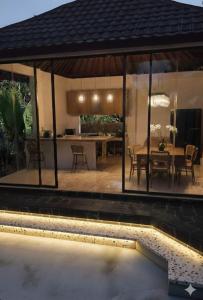 a pavilion with a table and a dining room at Umah Pororo in Karangasem