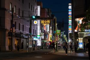 a busy city street at night with neon signs at Mori-no-Hotel Sendai in Sendai