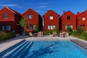 a swimming pool in front of a row of red houses at Sandhamn Seglarhotell in Sandhamn