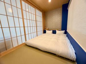 a small bedroom with a white bed in a room at TEN APARTMENT HOTEL in Fukuoka