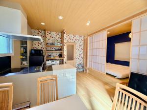 a kitchen and living room with a bed in the background at TEN APARTMENT HOTEL in Fukuoka