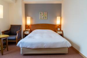 a bedroom with a bed and a chair and a table at Mori-no-Hotel Sendai in Sendai +12 photos