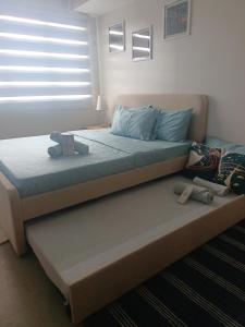 a bed with blue pillows and a window in a room at Carol sweet room in Cebu City +6 photos