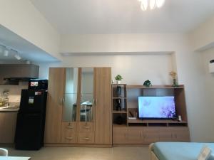 a living room with a television and a kitchen at Carol sweet room in Cebu City