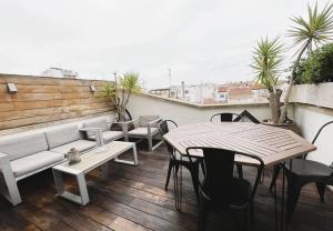 a balcony with a couch and tables and chairs at Attic Center Sitges in Sitges