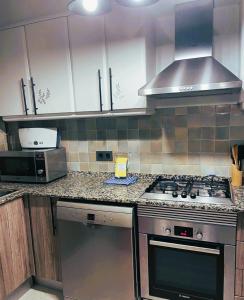 a kitchen with a stove and a microwave at Attic Center Sitges in Sitges +7 photos