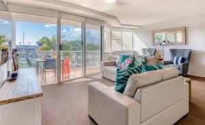 a living room with a couch and a table at Sailport Mooloolaba Apartments in Mooloolaba