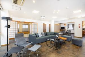 a living room with a blue couch and chairs at Bijou Suites AI PREMIUM in Osaka