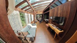 a living room with a couch and a flat screen tv at Casa de Madeira - Sao Jorge GO in Sao Jorge