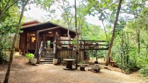 a small cabin in the woods with a porch at Casa de Madeira - Sao Jorge GO in Sao Jorge