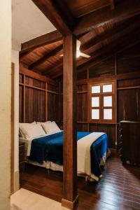a bedroom with two beds in a room with wooden walls at Casa de Madeira - Sao Jorge GO in Sao Jorge
