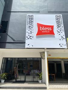 a sign on the side of a building with a glass house at Bless Red Hotels in Sintang