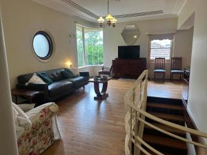 a living room with a couch and a table at Gracious 1930s Art Deco House in Gosford