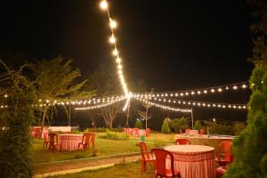 a group of tables and chairs under a string of lights at Hampi Blue Moon Resort in Munirābād