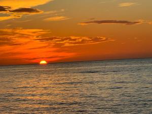 an orange sunset over the ocean with the sun setting at Oceanfront retreat, Hollywood Beach ,Miami Florida in Hollywood