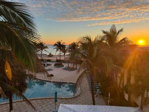 a view of a resort with a pool and palm trees at Oceanfront retreat, Hollywood Beach ,Miami Florida in Hollywood