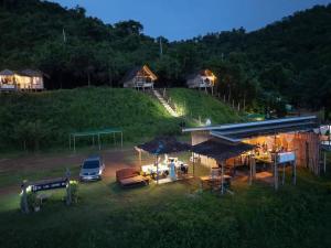 a group of people standing in a yard with a building at Homestay with Rive View Bann Good View in Ban Hua Phrong