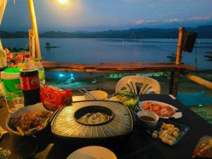 a table with food on it with a view of the water at Homestay with Rive View Bann Good View in Ban Hua Phrong