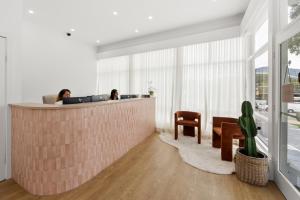 two people sitting at a counter in an office at The Palms Motel- Formerly Flinders Motel in Wollongong