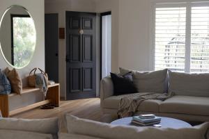 a living room with a couch and a mirror at Sea Notes Yamba in Yamba