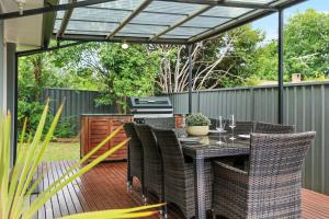 a patio with a table and chairs under a pergola at Belle in Bowral in Bowral +3 photos