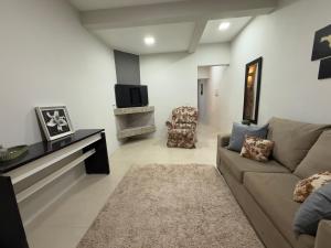 a living room with a couch and a tv at Sobrado NOVO próximo BR 290 in São Gabriel