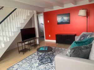 a living room with red walls and a couch and a table at Iceberg Lookout in Twillingate