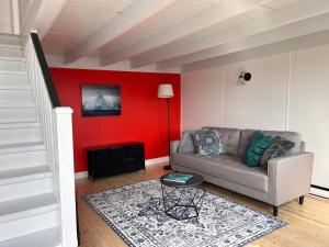 a living room with a couch and a red wall at Iceberg Lookout in Twillingate