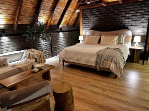 a bedroom with a bed and a brick wall at Hacienda El Rejo in Machachi
