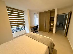 ein Schlafzimmer mit Bett, Schreibtisch und Fenster in der Unterkunft SextoMaíz in Morelia