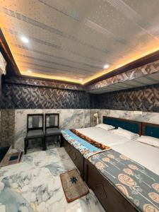 two beds in a room with marble walls at Samriddhi UrbanStay in Ayodhya