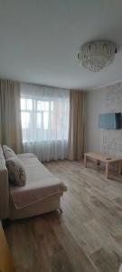 a living room with a bed and a table at Рахмет in Petropavlovsk