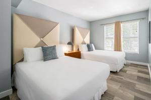 a bedroom with two beds and a window at Kasa Impala Miami Beach in Miami Beach