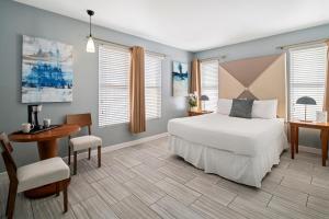 a bedroom with a bed and a table and a desk at Kasa Impala Miami Beach in Miami Beach