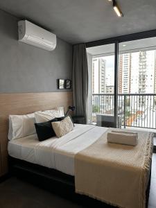 a bedroom with a large bed with a large window at Almagah 227 - Studios de Alto Padrão no Tatuapé - SP in São Paulo +187 photos