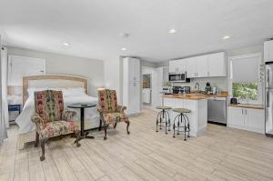 a bedroom with a bed and two chairs and a kitchen at The Reserve Retreat in Sarasota