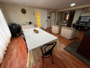 a living room with a white table and chairs at Espaciosa casa familiar en Queule in Nehuin