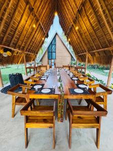 a long wooden table in a pavilion with chairs at Deduru Oya Cinnamon Gardens in Barandara