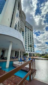 a large building with blue chairs in front of it at Tropical Executive 924 in Manaus