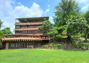 a large building with stairs and trees in front of it at สายชลวิว ริเวอร์แคว in Ban Wang Yen