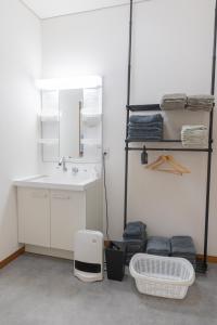 a bathroom with a sink and a mirror and a shelf at 勝山駅徒歩1分 恐竜博物館車5分スキージャム15分 BBQ可能 シアタールーム Kidsルーム完備 駅前好立地 in Katsuyama +54 photos