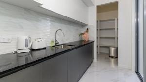 a kitchen with a sink and a counter top at Solander Sanctuary By The Water in Banksia Beach