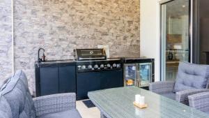 a kitchen with a stove and a table with chairs at Solander Sanctuary By The Water in Banksia Beach