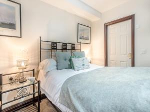 a bedroom with a bed with blue pillows at Berwyn Bank in Gilcrux +26 photos