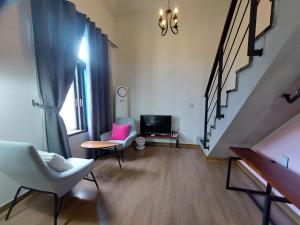a living room with two chairs and a tv at 진우 프레스티지 호텔 in Okp'o-ri