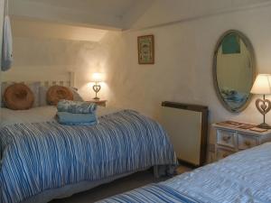 a bedroom with two beds and a mirror at Horseshoe Cottage in Starbotton +8 photos